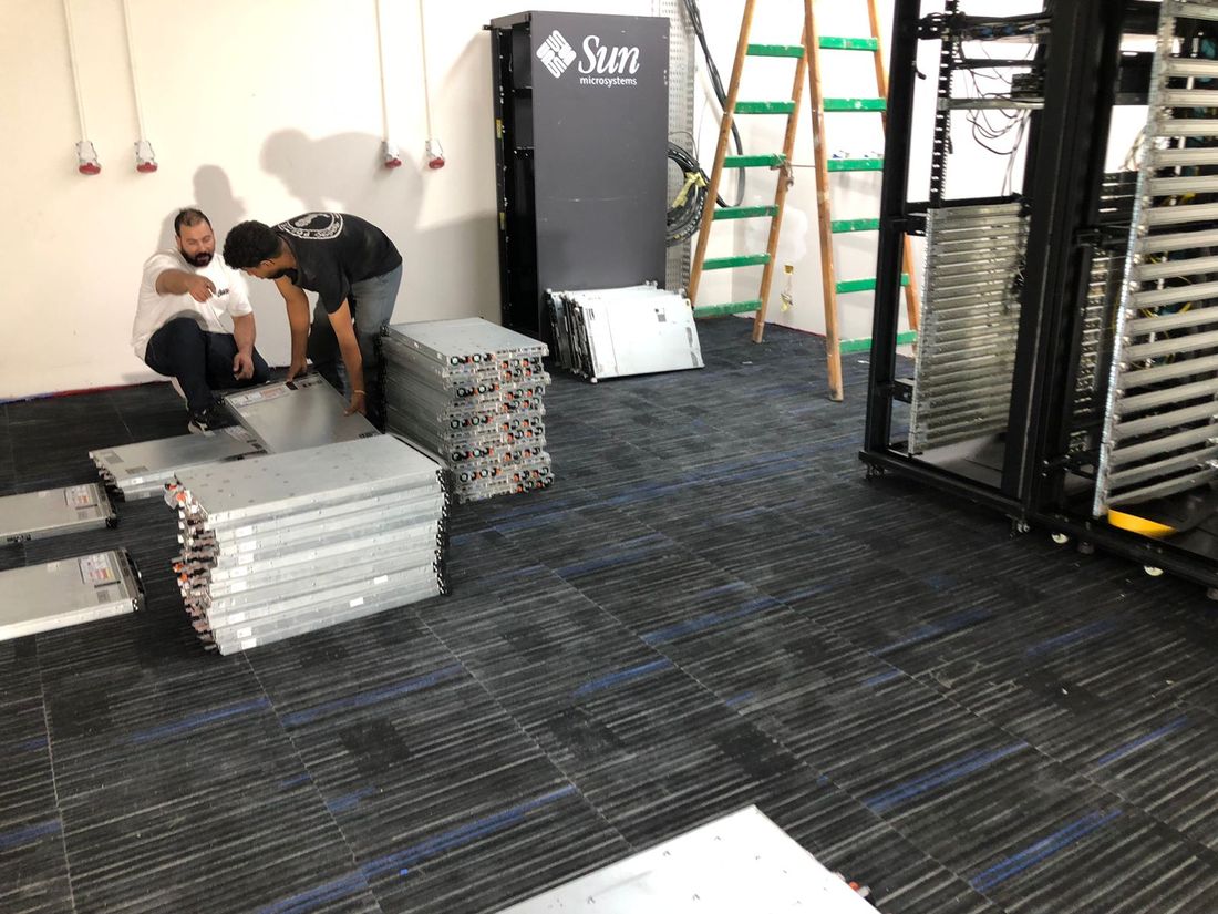 Two Stark Technology engineers assembling rack rails on site