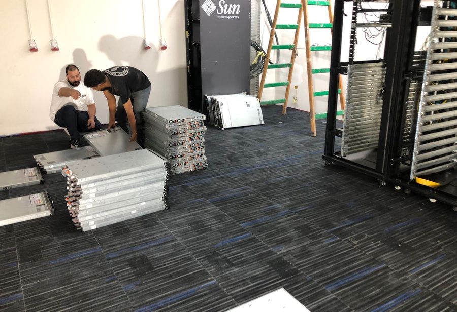 Stark engineers positioning racks during a data centre build